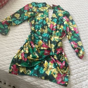 Es un traje corto muy bonito, color verde con flores amarillas y rosadas.